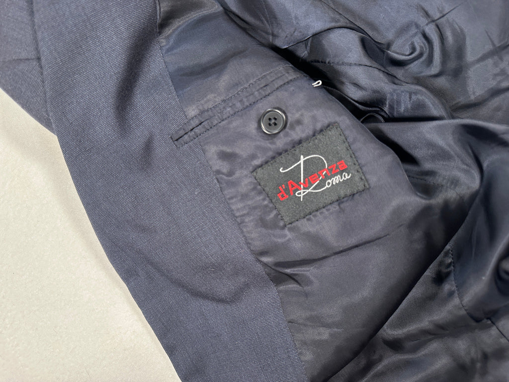 Close-up of a dark gray jacket with a brand label on a light beige background